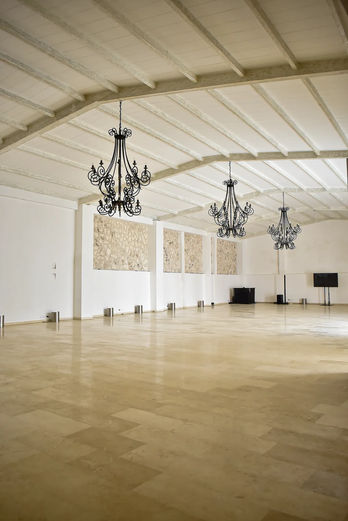 Perspectiva de un salón diáfano con piso claro y lámparas colgantes