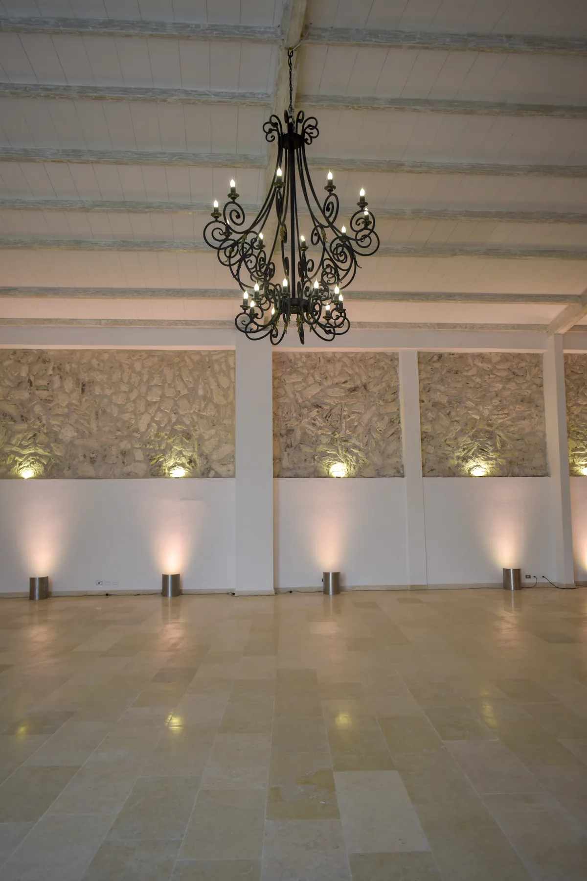 Espacio interior de Casa Real con lámpara central y patio al fondo